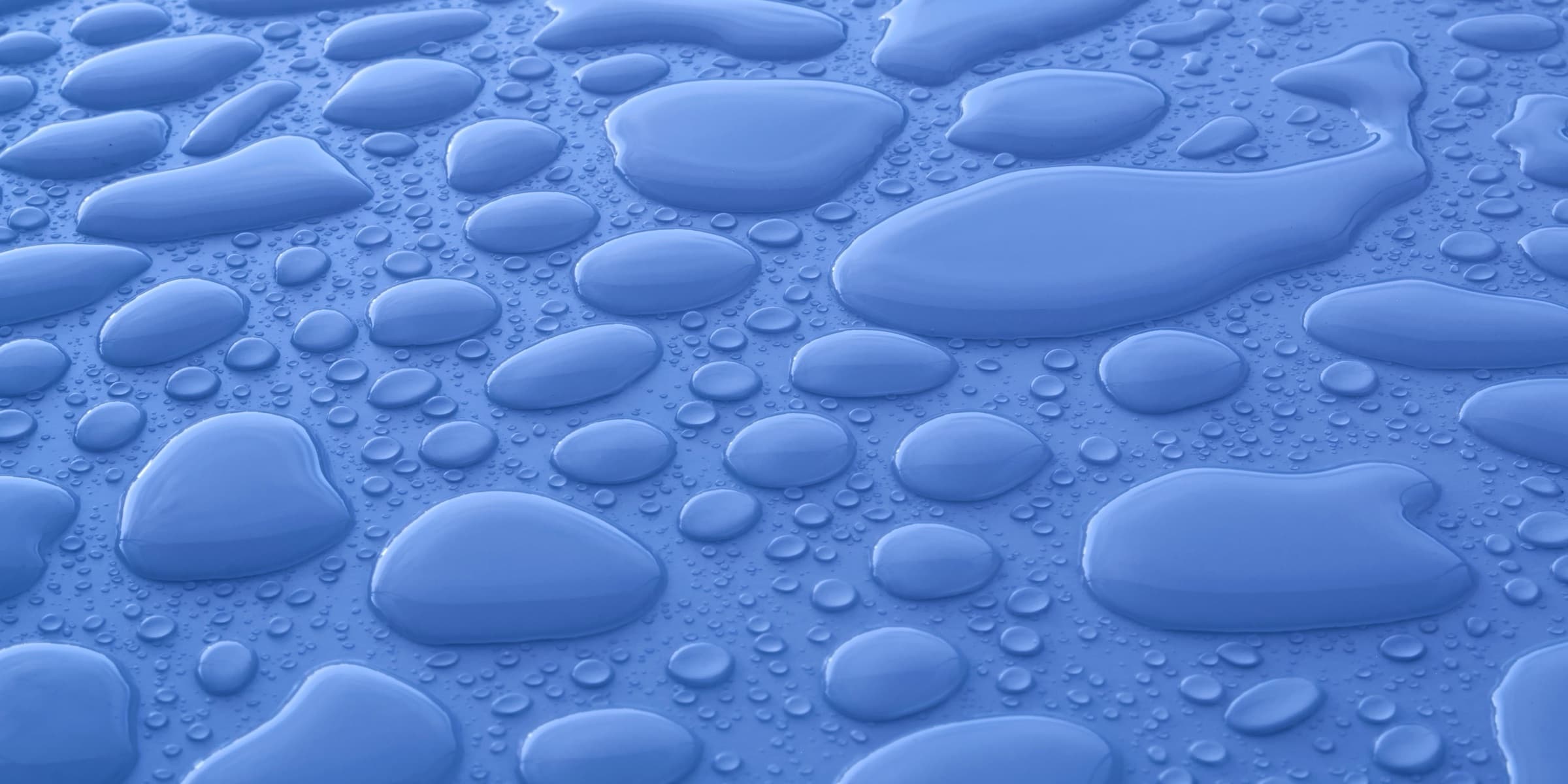 Large transparent drops on a blue surface