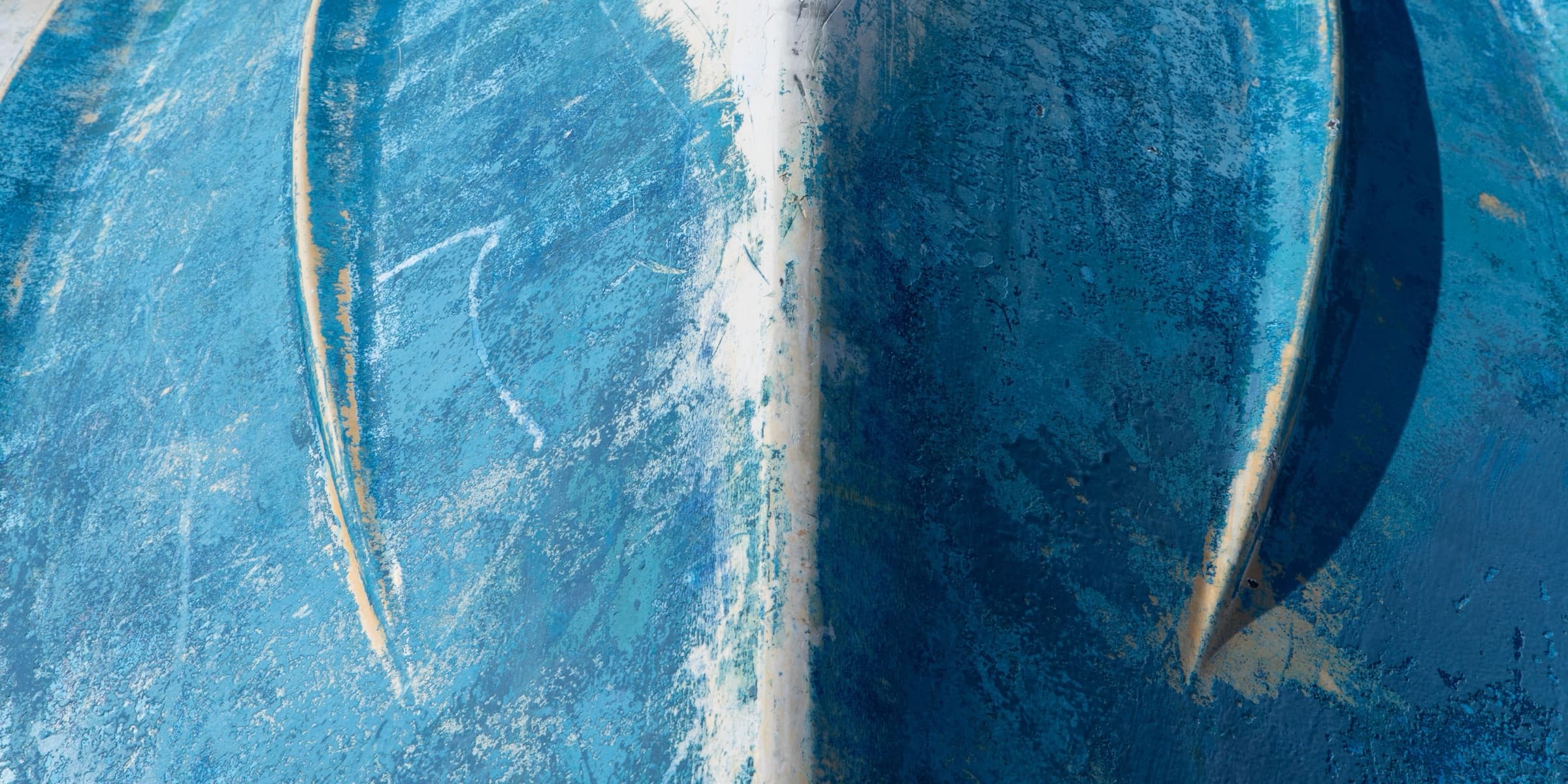 Underside of a weathered blue boat hull